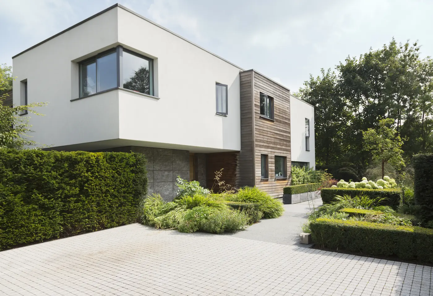 Modern home exterior with clean lines, hedges and gravel courtyard