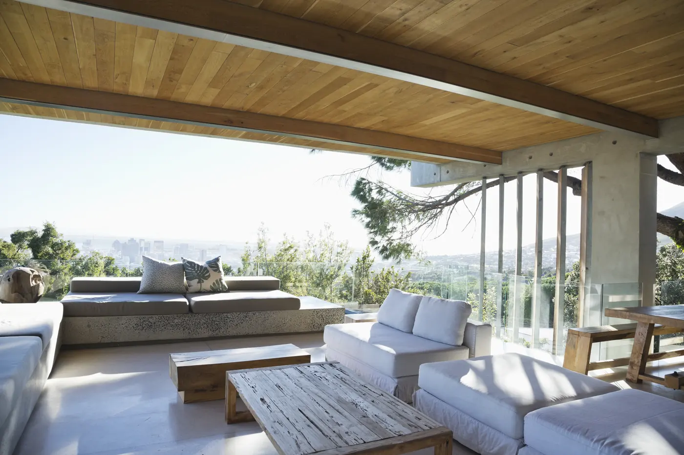 Covered outdoor living terrace with fireplace and warm wood ceiling