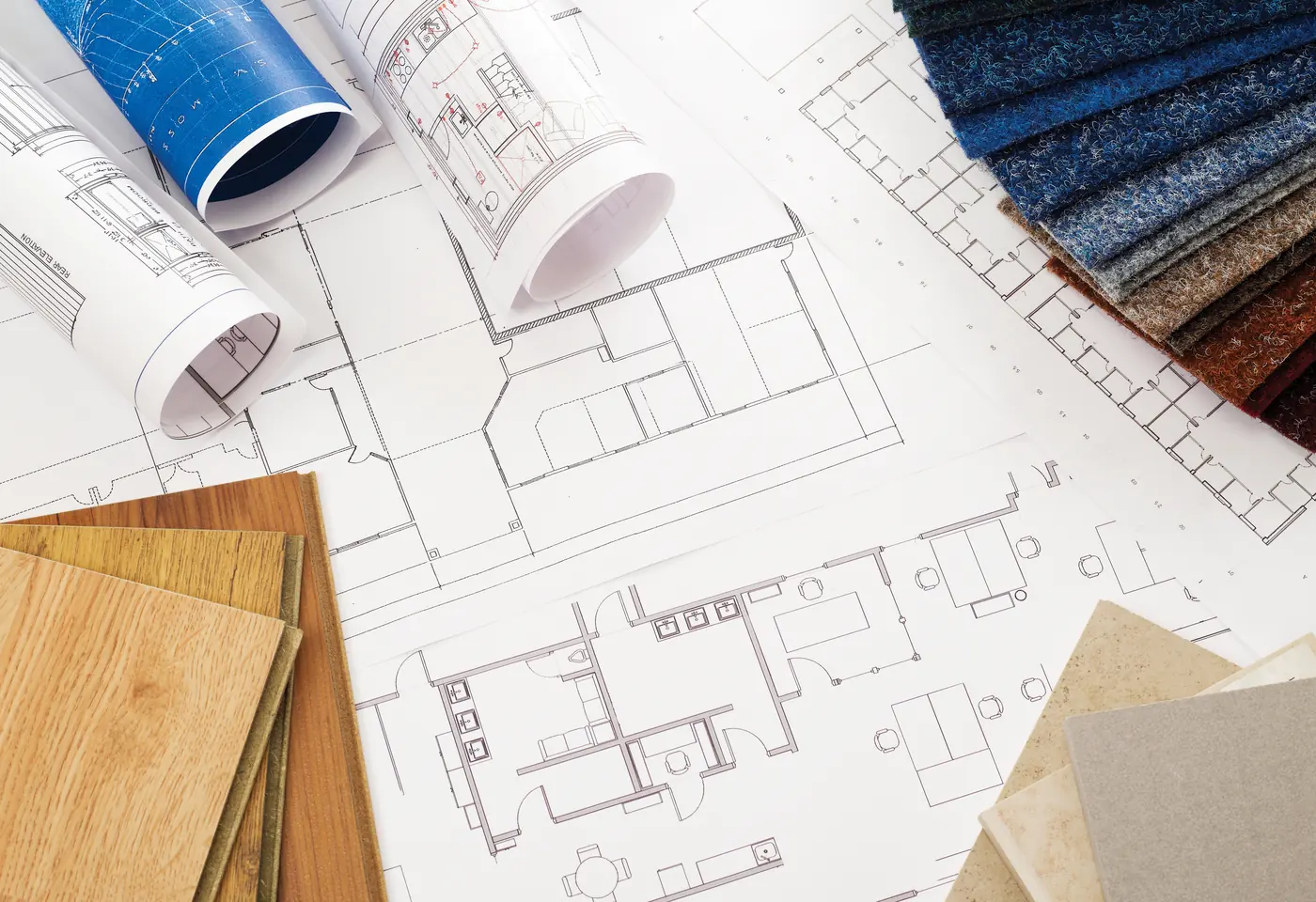Blueprints with wood and stone material samples laid out for planning