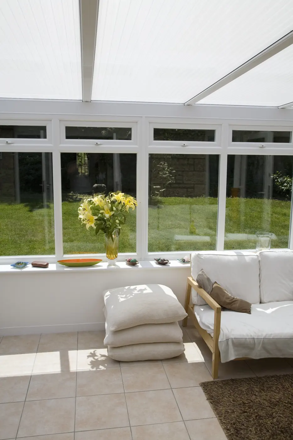 Bright finished sunroom with windows and fresh flowers