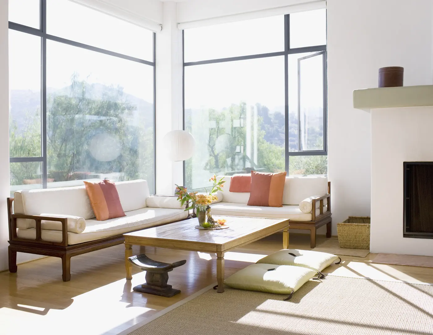 Bright sunroom living space with fireplace and garden views